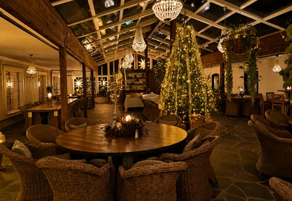 Evening setting with Christmas decorations beneath the glass roof at Lögnäs Gård